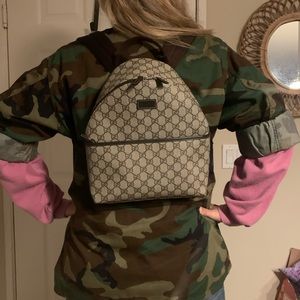 Authentic Gucci small GG Supreme canvas backpack, w brown leather details.